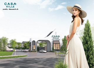 A woman standing next to the modern entrance gate of the Casa Ville housing project by Q House.